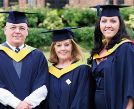 Family pose for photo at Graduation ceremony